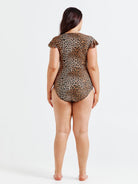Person wearing a leopard print swimsuit on a white background