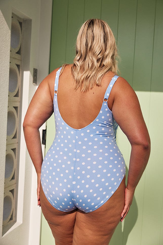 Blonde model showing back of light blue and white dots one piece