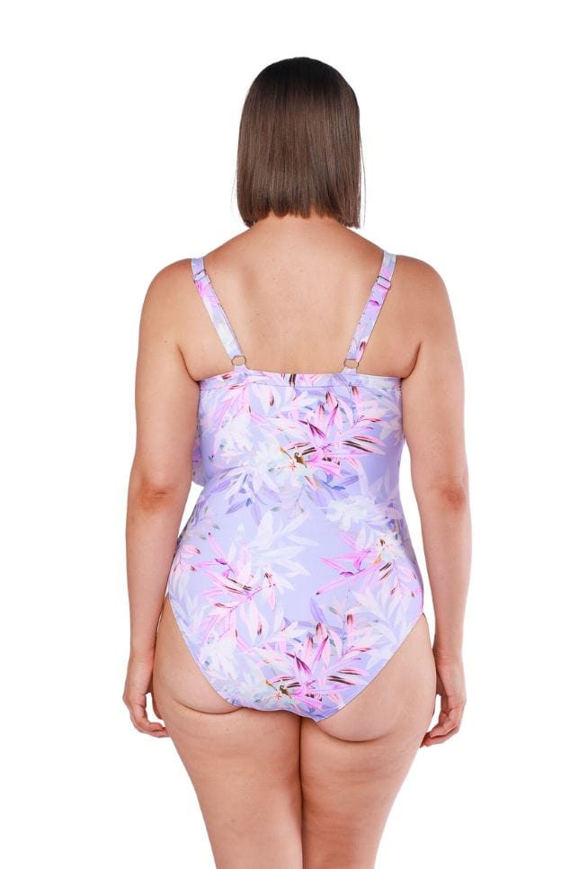 Brunette model wearing floral printed one piece with ruffles and adjustable straps