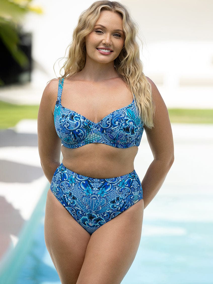 Woman wearing a blue patterned bikini by a pool