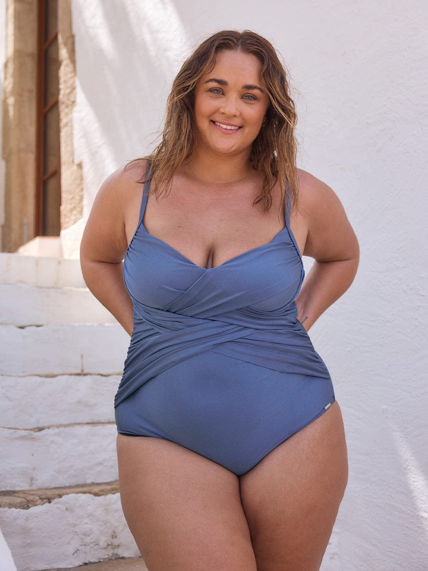 Curve woman wearing a metallic steel one piece with criss cross detail