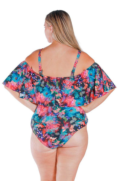 Back view of blonde model wearing pink and blue floral print off shoulder one piece with straps on 