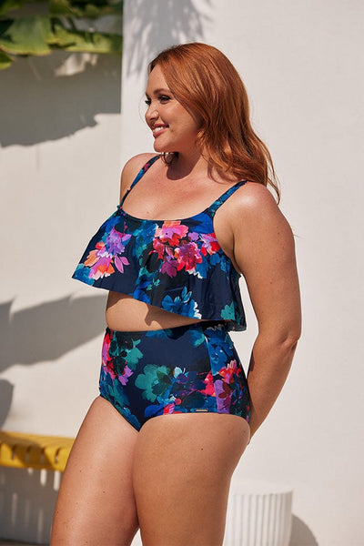 Side of model wearing a plus size frill bikini top with adjustable straps in tones of navy pink and purple