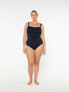 Woman wearing a black swimsuit on a white background