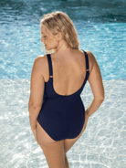 Back of model wearing a scoop back navy one piece with faux wrap tie