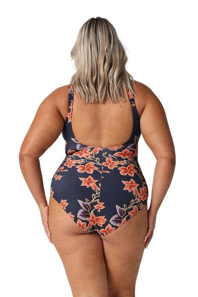 Back of model wearing floral scoop back one piece with adjustable straps in navy and orange 