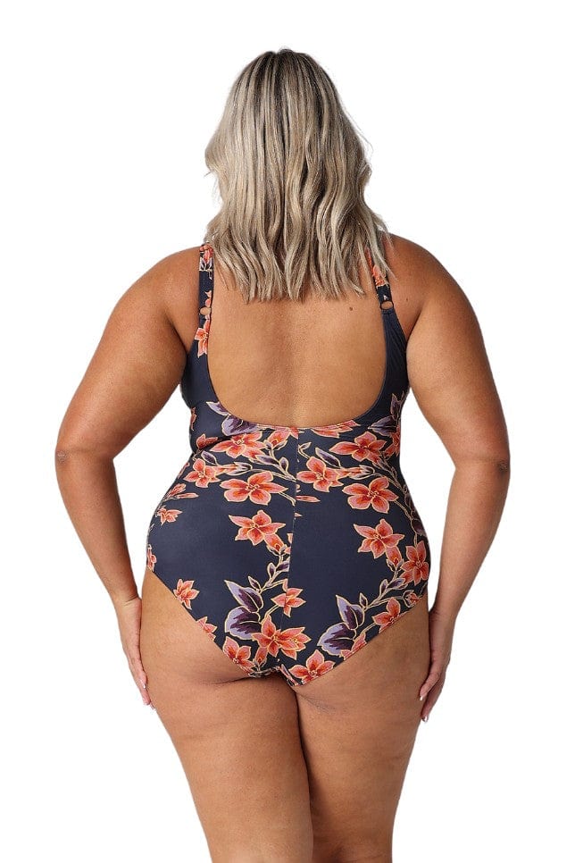 Back of model wearing floral scoop back one piece with adjustable straps in navy and orange 
