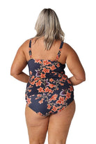 Back of blonde model in studio wearing  full coverage navy and orange floral high waisted bikini pant