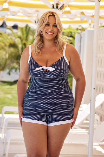 Blonde model wearing navy and white dots boyleg swimsuit