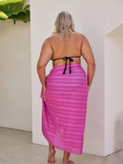 Model showing off back of curve sarong with pom pom detail