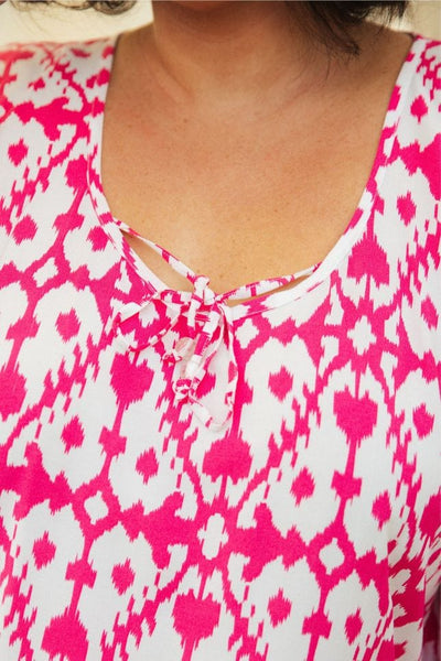close up photo of model in the pink and white kaftan showing the tie detail at the front