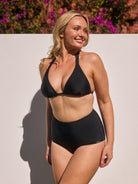 Blonde woman by pool wearing high waisted pant bottom for curve women
