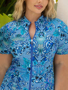 Woman wearing a blue patterned dress with a zipper.