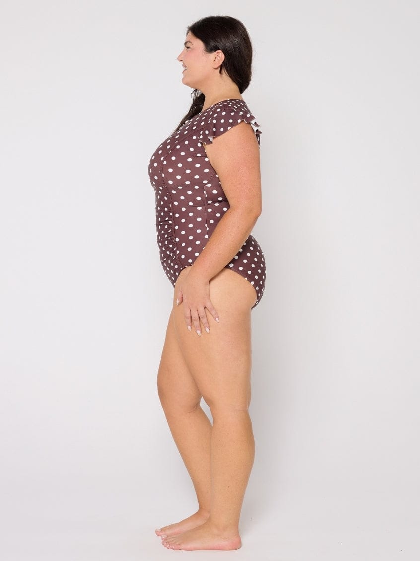 Woman wearing a polka dot swimsuit on a white background