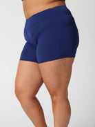 Model standing in pool showing flattering high waisted chlorine resistant boy leg swim pant in navy
