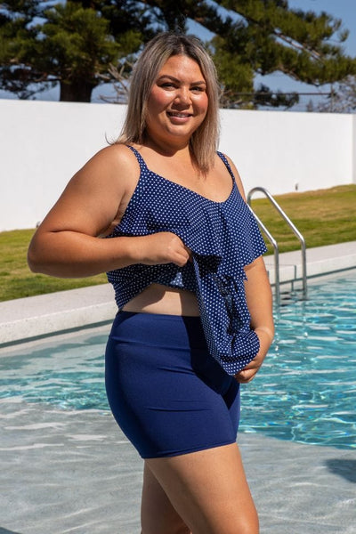 Model standing in pool showing flattering high waisted chlorine resistant boy leg swim pant in navy