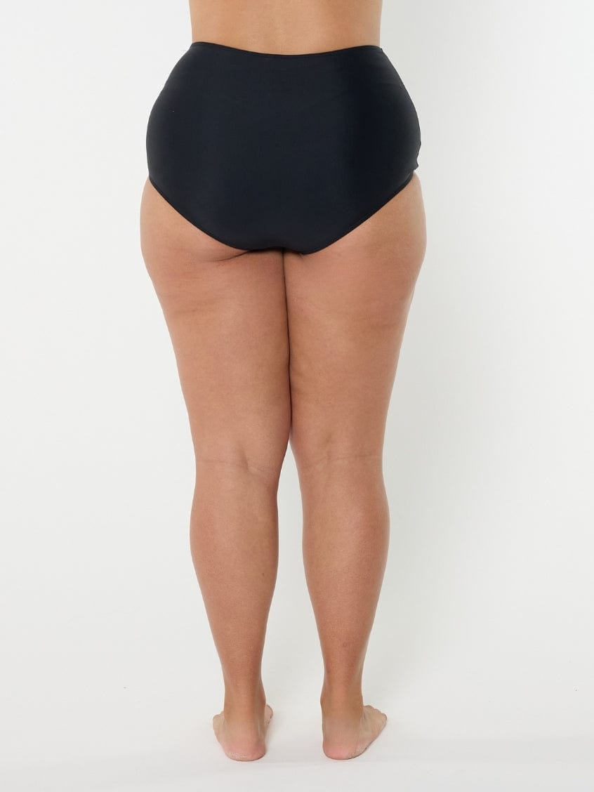 Person wearing black high-waisted bikini bottoms on a white background