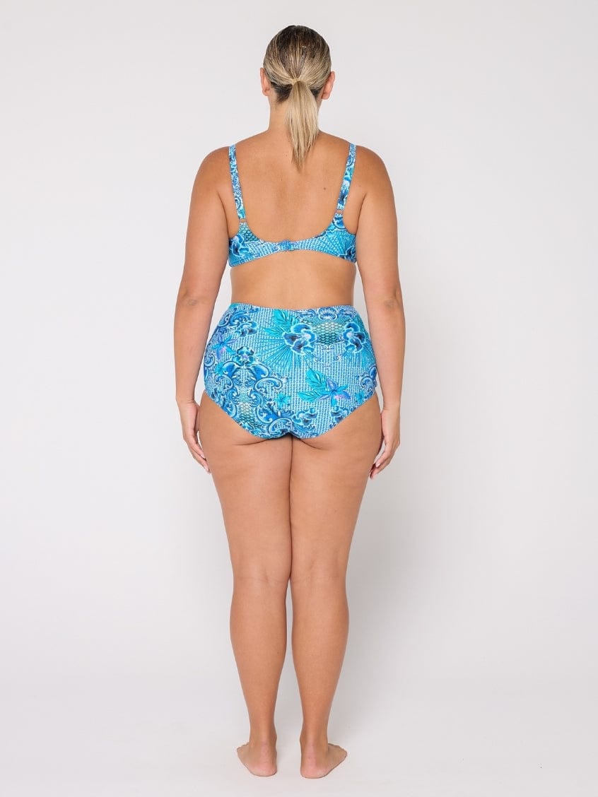 Woman wearing a blue floral bikini set on a white background