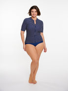 Woman wearing a blue polka dot swimsuit on a white background