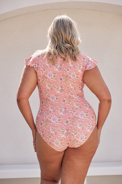 Blonde model wearing light pink floral frill sleeve one piece