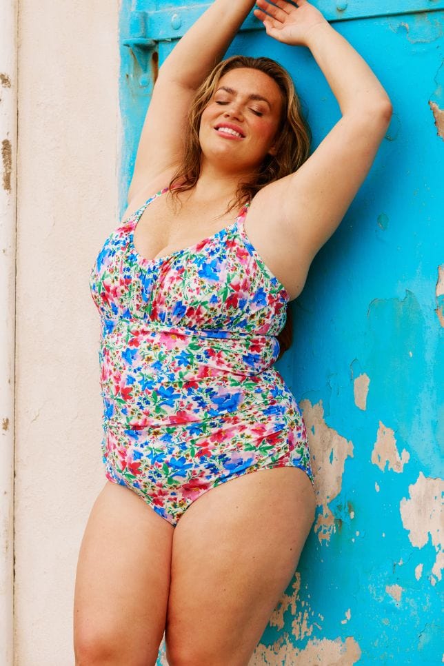 Model wearing flattering plus size underwire ruched tankini top in colourful floral print