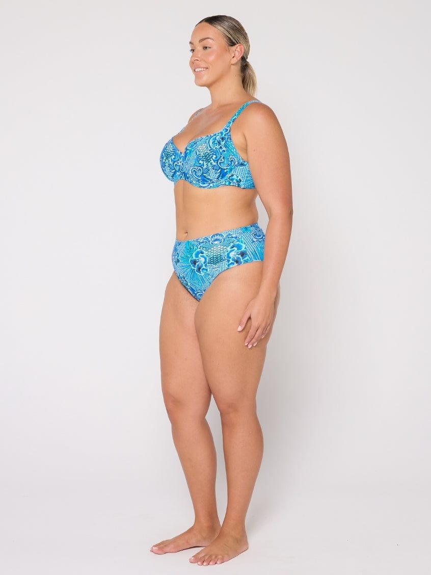 Woman wearing a blue patterned bikini set on a white background