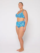 Woman wearing a blue floral bikini set on a white background