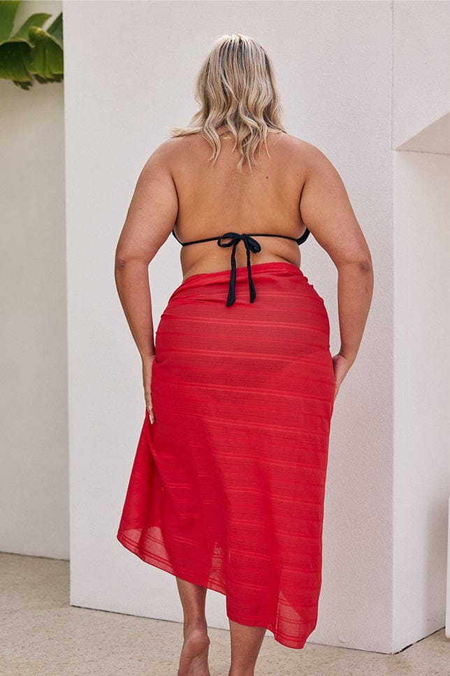 Blonde model showing back of long red sarong