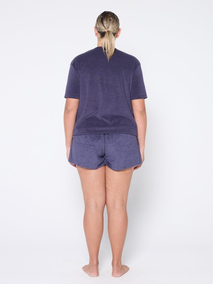 Person wearing navy t-shirt and shorts set on a white background