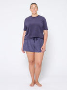 Woman wearing a navy terry towelling set on a white background