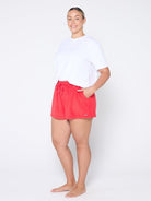 Person wearing red shorts and a white shirt on a white background