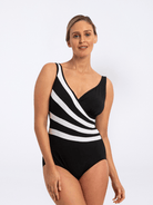 Woman wearing a black and white striped swimsuit on a white background