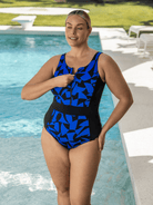 Woman wearing a blue and black chlorine resistant swimsuit by a pool