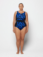 Woman wearing a blue and black patterned one-piece swimsuit on a white background