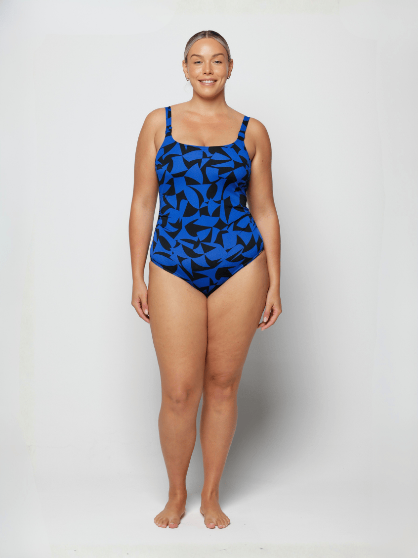 Woman wearing a blue and black patterned swimsuit on a white background
