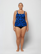 Curve woman wearing a blue and black chlorine resistant tank tankini top in studio
