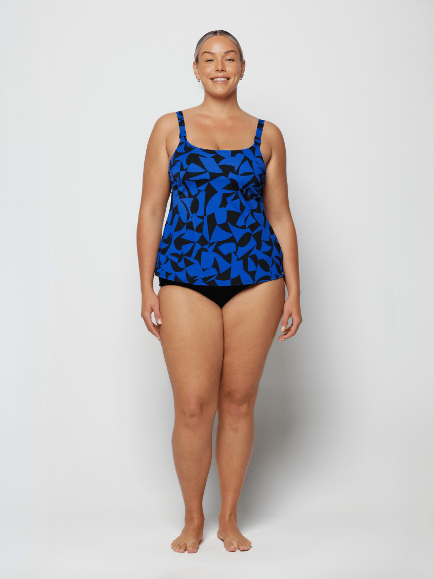 Curve woman wearing a blue and black chlorine resistant tank tankini top in studio