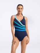 Woman wearing a blue and navy striped swimsuit on a white background