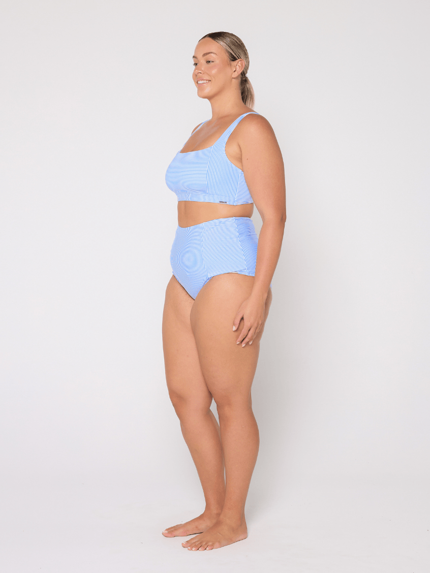 Woman wearing a light blue bikini set on a white background