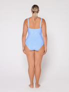 Woman wearing a light blue V neck swimsuit with adjustable straps on a white background