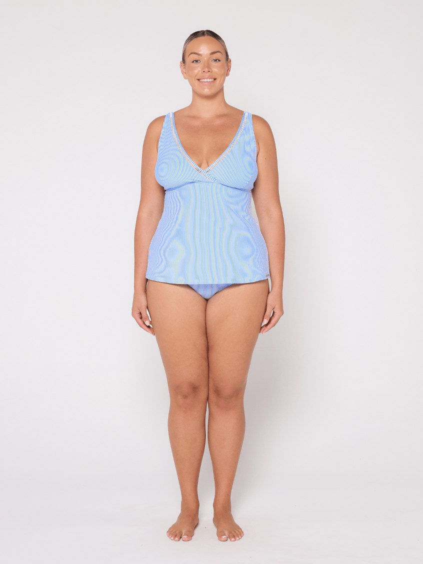 Woman wearing a light blue swimsuit against a white background