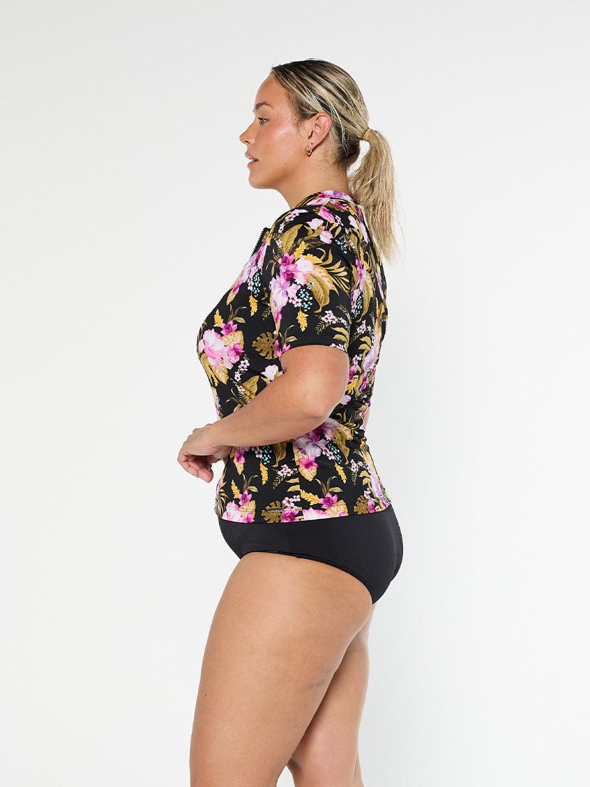 Blonde model shows the side of pool proof short sleeve tropical rash vest