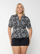 Front of blonde model in studio wearing plus size rash vest with zip front detail in paisley chlorine resistant