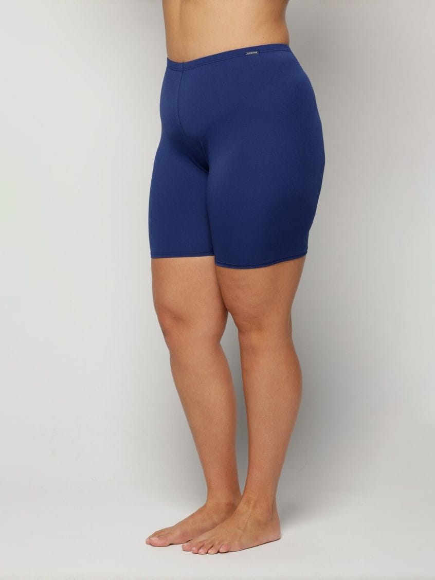 Person wearing blue swim chlorine resistant shorts on a plain background