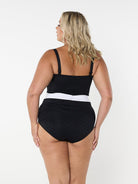 Woman wearing a black swimsuit with a white waistband on a white background