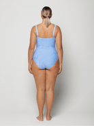 Woman wearing a blue sailor stripe swimsuit on a white background