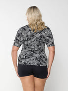 Back of model wearing rash vest with full zip through in paisley print for curve women