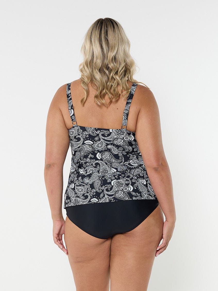 Blonde woman in studio wearing plus size tank tankini top with adjustable straps in black and white paisley print