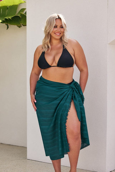 blonde model wearing teal sarong and black triangle bikini