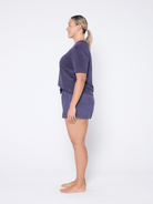 Woman wearing a navy t shirt and matching short set on a white background